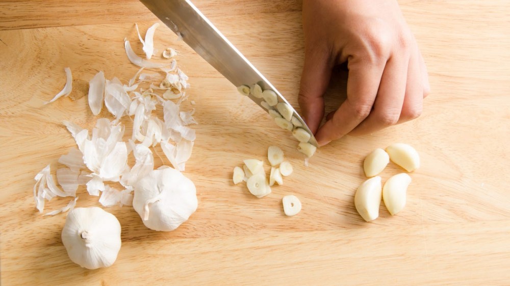 A person chops garlic.