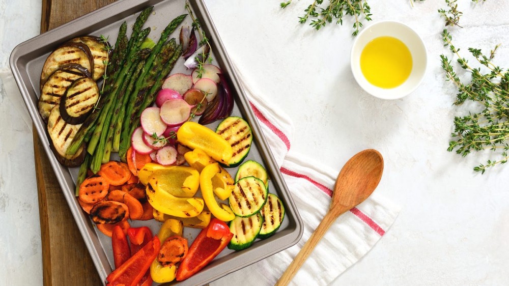 A baking sheet has different roasted vegetables on it.